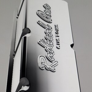 May include: A silver valve cover with the words "Railroad One Customs" embossed on it.