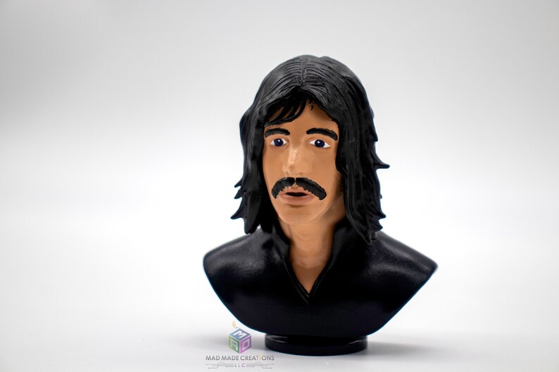 May include: A black and white 3D printed bust of a man with long black hair and a mustache. The bust is on a small black base.