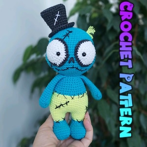 May include: A handmade crochet doll in a zombie-like design. The doll features a blue body, yellow pants, and a black top hat. The eyes are large and white with black outlines. The text "CROCHET PATTERN" is visible on the right side.