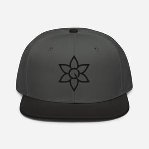 May include: A dark grey baseball cap with a black peak. The cap displays a black floral design on the front. The hat is a flat-billed style, suitable for casual wear.
