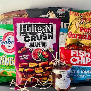 May include: A gift basket filled with various snacks, including bags of chips, pretzel pieces, and a jar of onion relish. The chips come in flavors like sour cream & onion, salt & vinegar, and jalapeño. The packaging features bold colors and text.