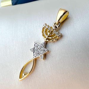 May include: A gold pendant necklace featuring a menorah and a Star of David, both adorned with clear cubic zirconia stones.