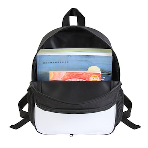 May include: A black and white backpack with a zippered front pocket. The backpack is open and has books inside.