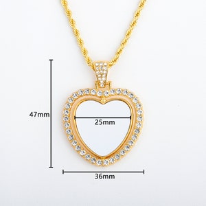 May include: Gold heart-shaped pendant necklace with a clear, blank space in the centre. The pendant is decorated with clear rhinestones and measures 36mm wide and 47mm tall. The pendant has a 25mm wide opening in the centre.