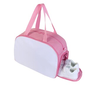 May include: Pink and white duffel bag with a zippered opening and a white interior. The bag is open and two white sneakers are visible inside.