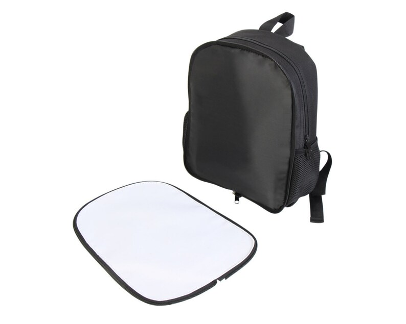 May include: A black backpack with a zippered front pocket and a mesh side pocket. The backpack is lying on a white surface next to a white blank sublimation transfer sheet.