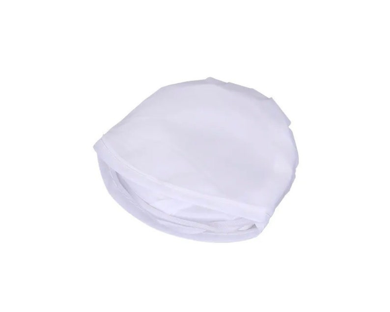 May include: A folded, white, semi-transparent fabric item, possibly a garment or accessory, against a white background. The fabric appears to be lightweight and has a slightly wrinkled texture. The item is folded into a compact shape.