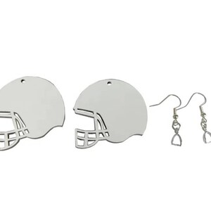 May include: A pair of silver earrings featuring a football helmet design. The earrings are on a silver hook.