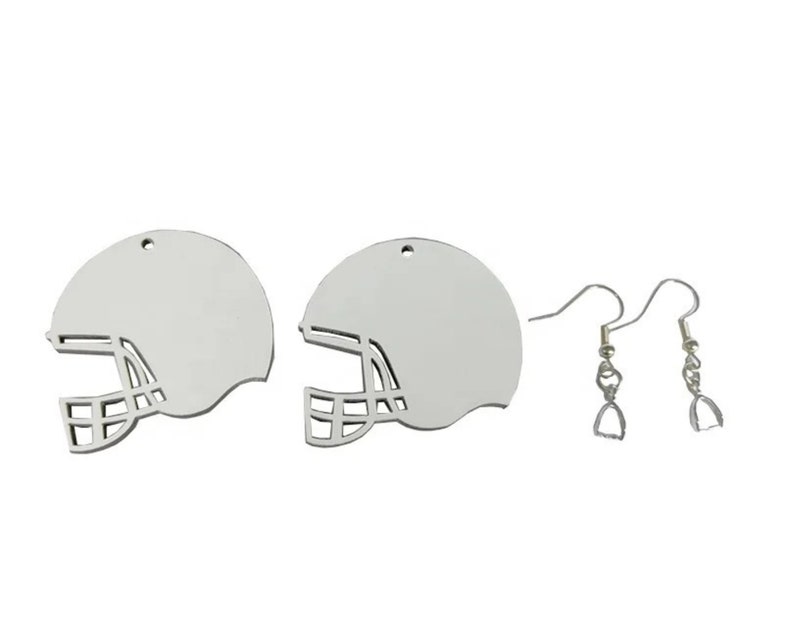 May include: A pair of silver earrings featuring a football helmet design. The earrings are on a silver hook.