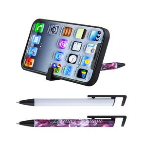 May include: Two pens with a built-in phone stand. One pen is white with a black stand, the other is purple with a floral design and the text "Lovelin Kalayu" on the barrel.