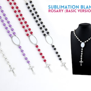 May include: Sublimation blank rosaries in white, purple, red, and black beads. Each rosary features an oval blank for customization and a silver-tone cross pendant. The text "SUBLIMATION BLANK ROSARY (BASIC VERSION)" is displayed in the image.