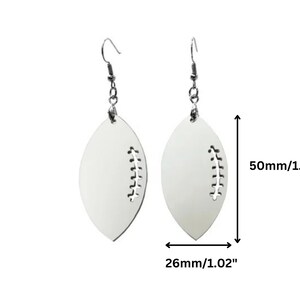 May include: White football-shaped earrings with a stitched detail. The earrings are approximately 2 inches long and 1 inch wide.