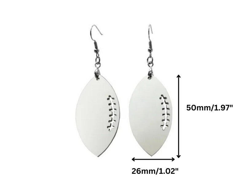 May include: White football-shaped earrings with a stitched detail. The earrings are approximately 2 inches long and 1 inch wide.
