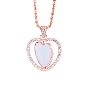 May include: A rose gold necklace featuring a heart-shaped pendant. The pendant is embellished with clear rhinestones and has a smaller heart-shaped opening in the centre.