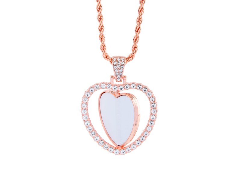 May include: A rose gold necklace featuring a heart-shaped pendant. The pendant is embellished with clear rhinestones and has a smaller heart-shaped opening in the centre.