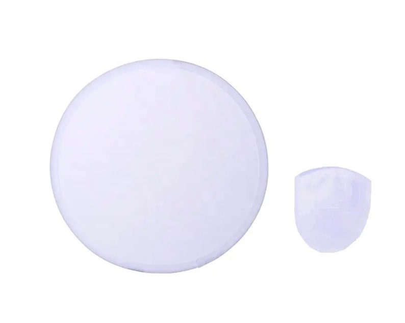 May include: A white, round object and a smaller, white, rounded object. The objects are set against a white background. The round object is a disc shape. The smaller object is a rounded, cup-like shape.