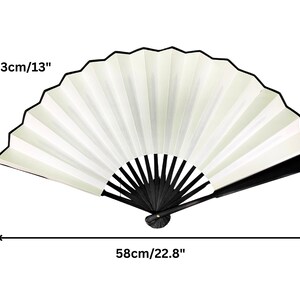 May include: A white folding fan with a black handle. The fan is 13 inches tall and 22.8 inches wide when open.