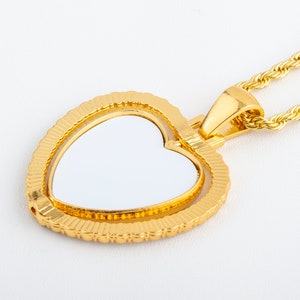 May include: A gold heart-shaped pendant with a white centre, attached to a gold rope chain.