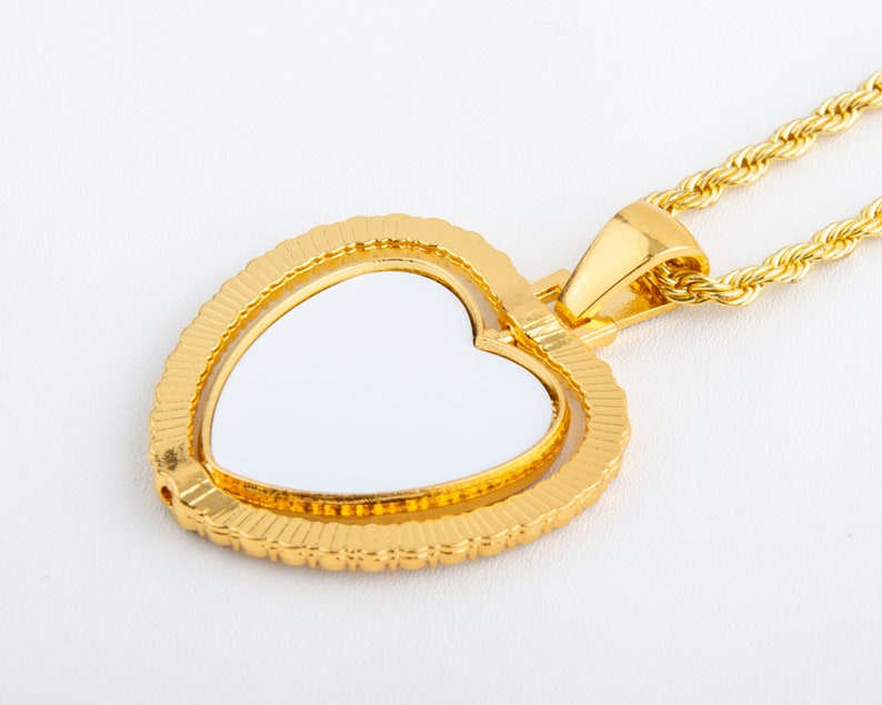 May include: A gold heart-shaped pendant with a white centre, attached to a gold rope chain.