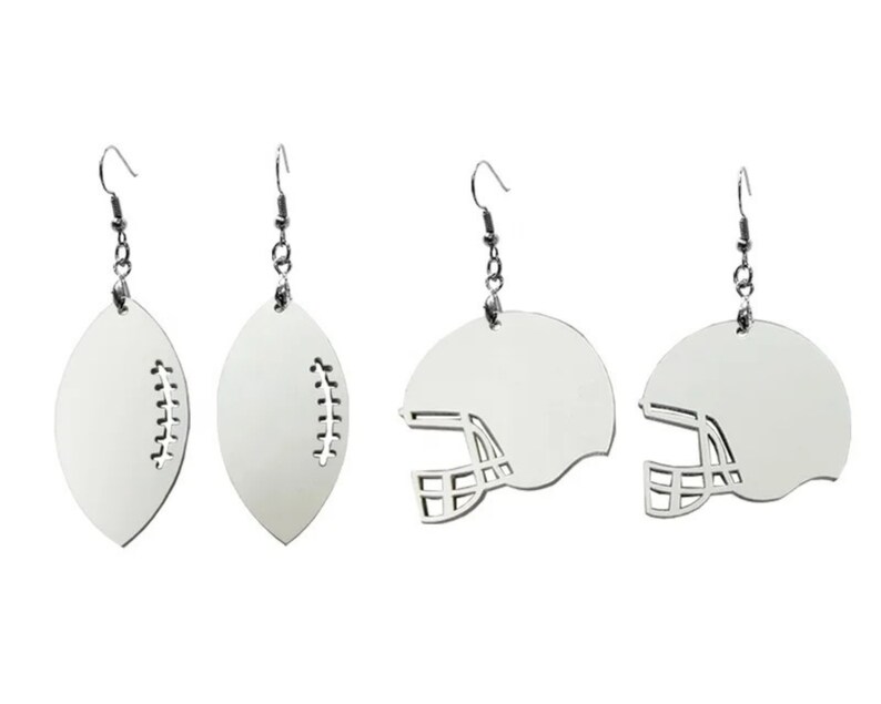 May include: A set of four silver earrings featuring two football and two football helmet designs. The earrings are made of metal and have a silver finish.