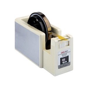 May include: A white tape dispenser with a gold tape roll. The dispenser has a clear plastic window and a black button labeled "OPEN". The dispenser has Chinese text on the side that reads "deli得力 安全不住平 OPEN 警告:内置刀片, 不适合3岁及以下儿童使用。"