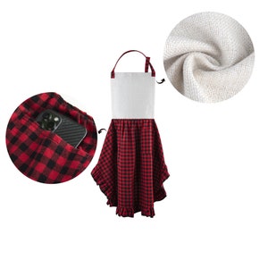 May include: A red and black checkered apron with a white linen top and a ruffled hem. The apron has a pocket on the front that can hold a phone.