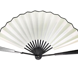 May include: A white folding fan with a black handle and black trim. The fan is closed and the handle is extended.