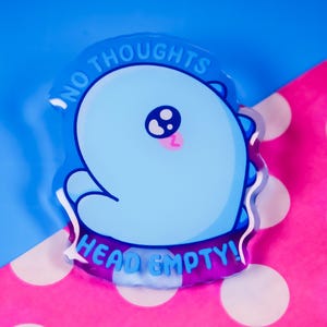 Può includere: Un portachiavi in acrilico trasparente blu e viola con un dinosauro blu dei cartoni animati con una lingua rosa e il testo "NO THOUGHTS HEAD EMPTY!"