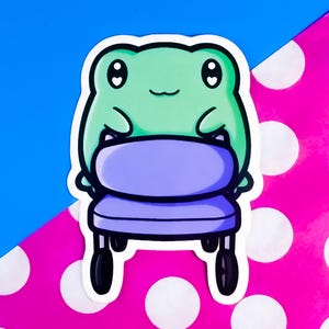 Puede incluir: Una pegatina con una rana de dibujos animados sosteniendo una silla morada. La rana es verde con ojos negros y una pequeña sonrisa. La silla tiene un asiento morado y patas negras. El fondo es azul y rosa con lunares blancos.