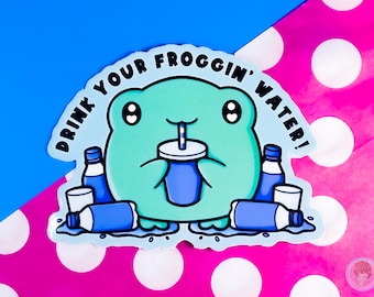 May include: A sticker featuring a cartoon frog with the text "DRINK YOUR FROGGIN' WATER!". The frog is light blue and drinking from a blue cup with a straw. Blue water bottles and cups surround the frog, with a pink and blue background.