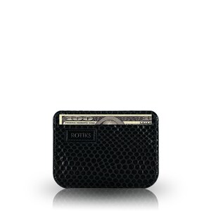 May include: A black leather wallet with a textured surface and a single bill of US currency sticking out of the top. The wallet has the word "ROTIKS" embossed on the front.