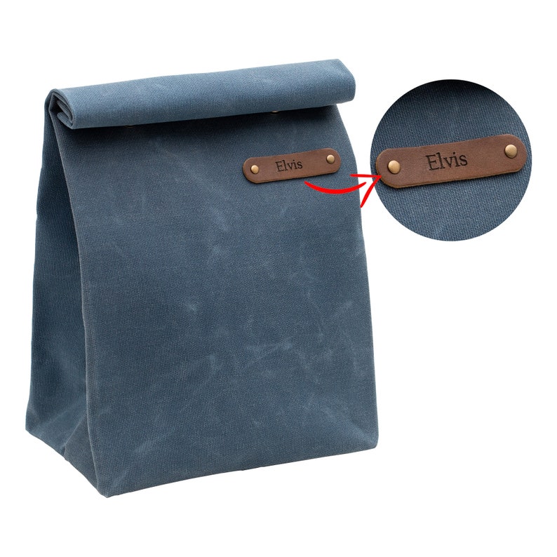 May include: A blue canvas lunch bag with a brown leather strap and the name "Elvis" embossed on it.