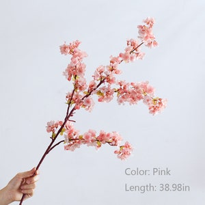 May include: A single pink artificial cherry blossom branch with delicate flowers. The branch is 38.98 inches long.