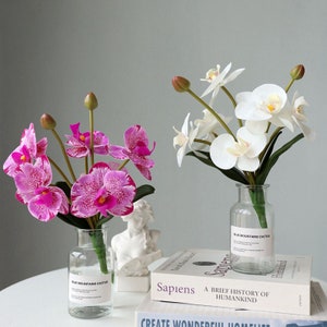 Konstgjord orkidé med fjärilar och bladverk av äkta Phalaenopsis, heminredning, bröllopsfest, mittpunkt