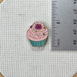Pink cupcake enamel needle minder with strong magnet, perfect for holding needles while cross stitching, embroidery, quilting, needlepoint or sewing. Fun drink-themed needle holder for stitchers.
