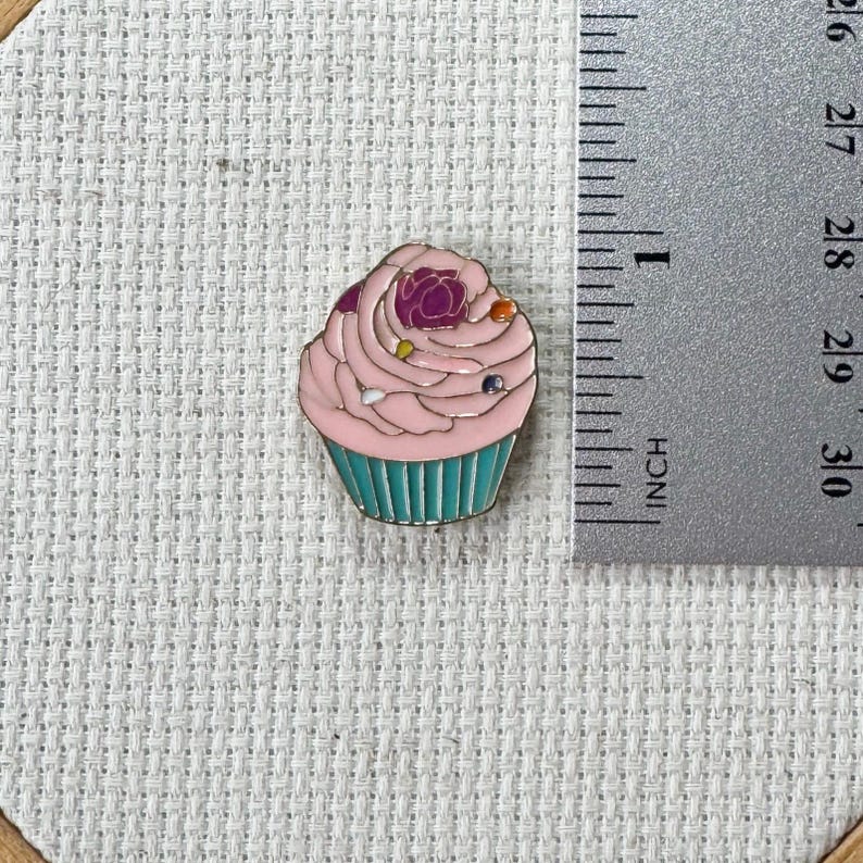 Pink cupcake enamel needle minder with strong magnet, perfect for holding needles while cross stitching, embroidery, quilting, needlepoint or sewing. Fun drink-themed needle holder for stitchers.
