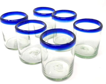 May include: Set of six clear glass tumblers with a blue rim. The glasses are perfect for serving water, juice, or cocktails.