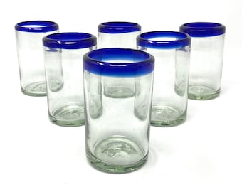 May include: Set of six clear glass drinking glasses with a blue rim. The glasses are all the same size and shape.
