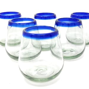May include: Set of six clear glass tumblers with a blue rim. The glasses are round and have a wide base.