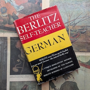 May include: A vintage Berlitz Self-Teacher German book. The cover is red, yellow, and black with the title in white. The book is on a background of a vintage newspaper with colorful illustrations.