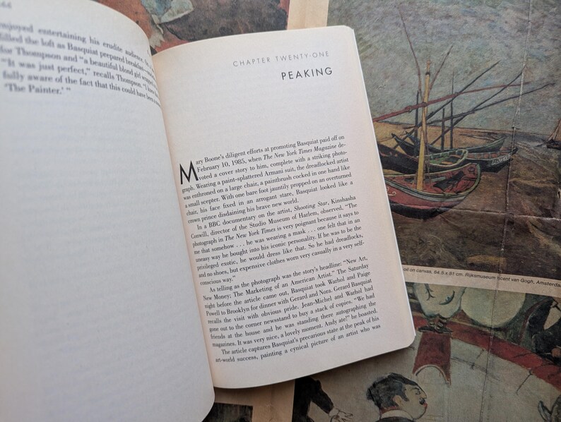 Puede incluir: Libro abierto con texto en una p&aacute;gina blanca, titulado "Cap&iacute;tulo Veintiuno: Peaking". El libro est&aacute; abierto en una p&aacute;gina de texto con una gran letra inicial. El fondo presenta una pintura de barcos.