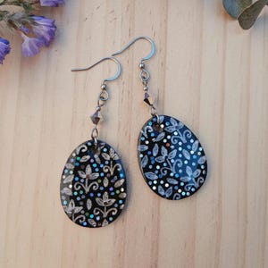 Pendientes artesanales negros con flores plateadas, pendientes florales pintados a mano con purpurina y cuenta Swarovski, pendientes ligeros