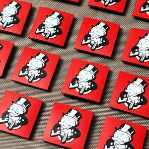 May include: A set of 12 red square tiles with a white cartoon image of a Monopoly Man holding a gun. Each tile has a different pose of the Monopoly Man.
