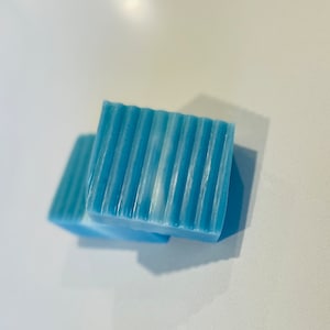 May include: Two bars of blue soap with a rippled texture.