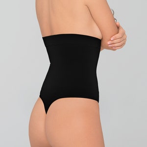 Puede incluir: Tanga negra de cintura alta con un diseño liso y sin costuras. La tanga tiene una pierna de corte alto y una espalda de tanga.