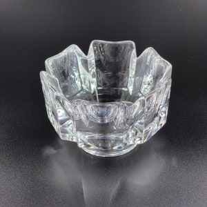 May include: A clear glass bowl with a geometric design. The bowl has a starburst shape with a flat base.