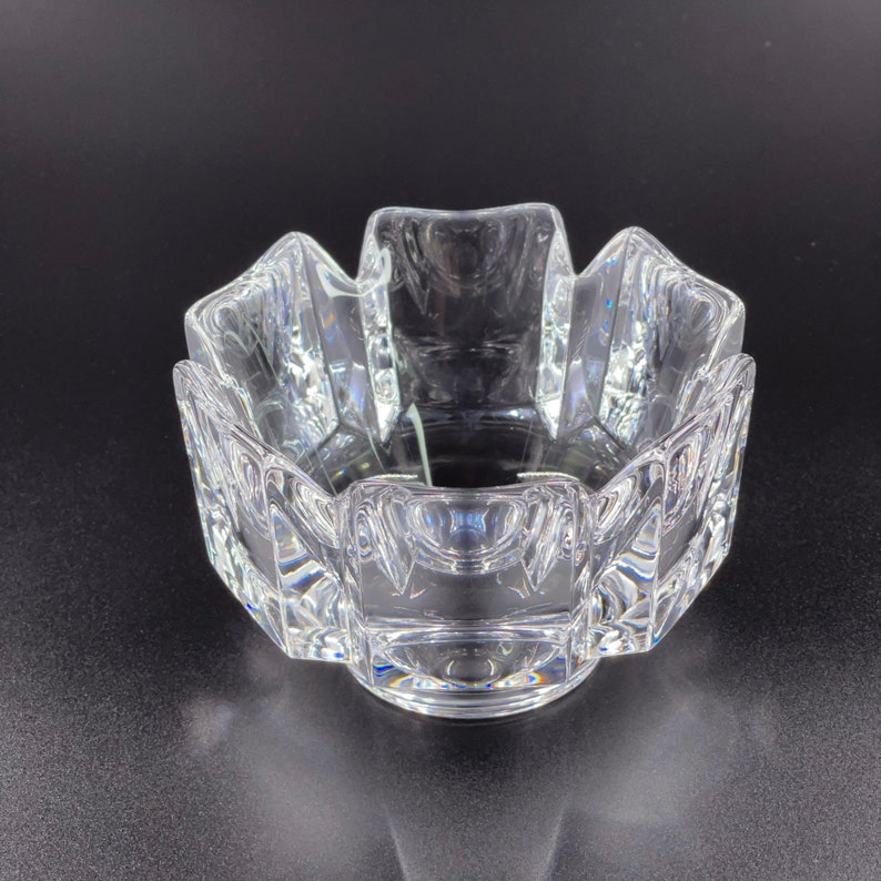 May include: A clear glass bowl with a geometric design. The bowl has a starburst pattern and is made of thick glass.