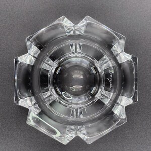 May include: A clear glass bowl with a starburst design and a raised center. The bowl is signed "Orrefors" on the bottom.