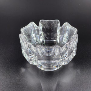 May include: A clear glass bowl with a geometric design. The bowl has a starburst shape with multiple facets.