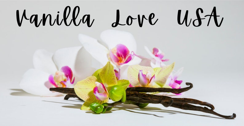 May include: Vanilla bean pods and white orchids with pink and yellow accents. The text "Vanilla Love USA" is written above the flowers.